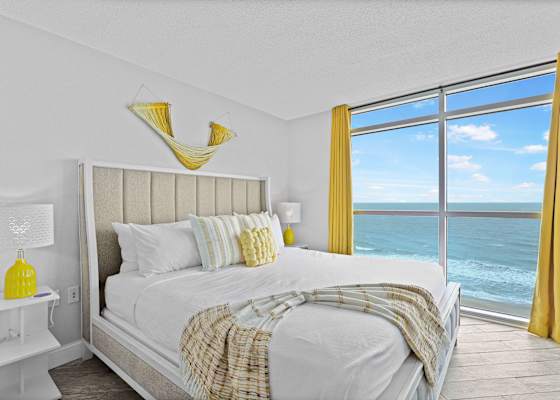 Wake up to panoramic ocean views in this sunlit, coastal-chic bedroom! Featuring a plush king bed, bright yellow accents, and floor-to-ceiling windows, it’s the perfect Myrtle Beach retreat for rest and relaxation.