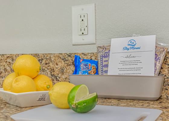 Thoughtful welcome touches on the kitchen counter, with fresh citrus, snacks, and a warm note to help guests feel at home upon arrival.