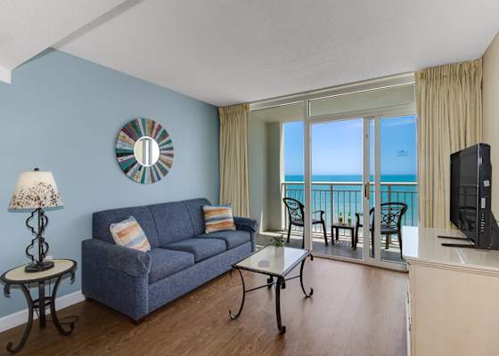 Soak in stunning ocean views from this cozy living space, complete with a comfy sofa, stylish décor, and private balcony access. Relax, recharge, and enjoy the serenity of beachside living.