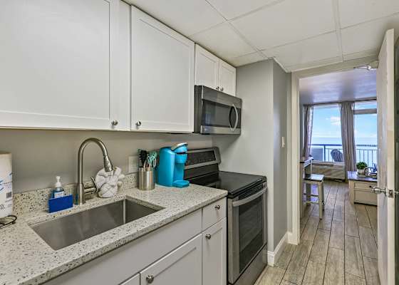 Cook with a view in this fully equipped kitchen featuring modern appliances, granite countertops, and ocean sights just steps away. Perfect for whipping up meals during your Myrtle Beach getaway!