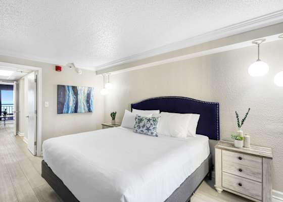 Unwind in comfort with this serene king bedroom, featuring soft lighting, coastal-inspired decor, and a plush mattress for a restful sleep. Wake up refreshed with a peek of the ocean just down the hall.