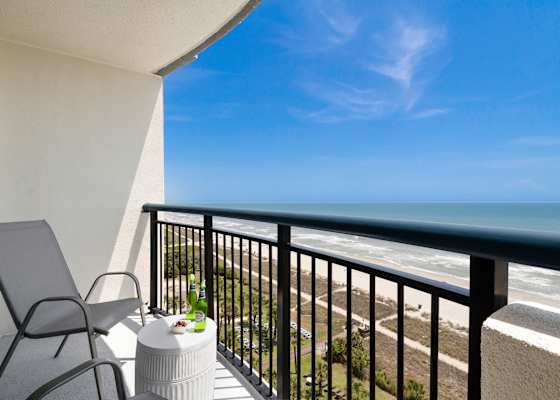 Step out onto your private balcony and soak in panoramic ocean views. With comfortable seating and a side table perfect for snacks or drinks, this serene spot invites you to unwind and enjoy the gentle sea breeze and the calming sound of the waves.