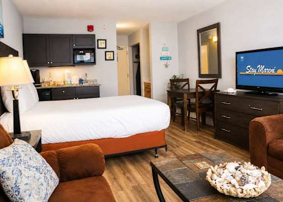 Relax in a thoughtfully updated studio featuring a plush Queen bed, cozy seating area, dedicated dining space, and convenient kitchenette.