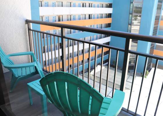 Private balcony featuring colorful Adirondack chairs and a small table overlooking the resort complex