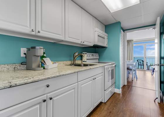 Prepare meals with ease in this fully equipped kitchen featuring sleek countertops, modern appliances, and a charming coastal vibe. Steps away from stunning ocean views to enhance your beach retreat!