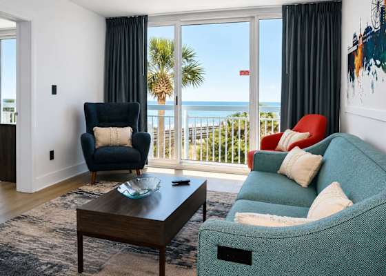 Unwind on our plush teal sofa right beneath the stunning watercolor skyline mural!