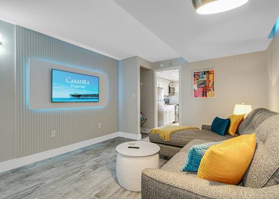 Relax in this cozy, living area featuring a plush sectional, accent lighting, and a Smart TV for entertainment. The soothing decor and comfortable seating make it an ideal spot to unwind after a day of exploring.