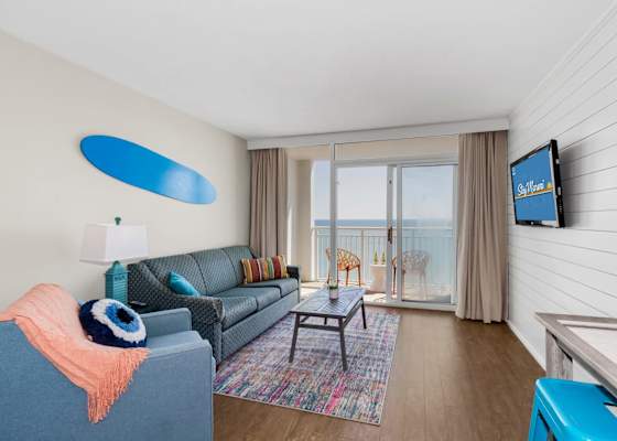 Bright, colorful, and full of charm, this cozy living area is perfect for relaxing after a day at the beach. Enjoy the ocean view from the balcony, cheerful decor, and comfortable seating that makes your stay as inviting as it is memorable.