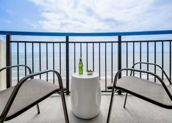 Step out onto your private balcony and soak in panoramic ocean views. With comfortable seating and a side table perfect for snacks or drinks, this serene spot invites you to unwind and enjoy the gentle sea breeze and the calming sound of the waves.