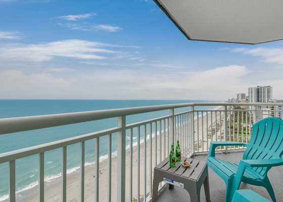 Private ocean-view balcony overlooking the beach, with outdoor seating for enjoying fresh coastal air and wide shoreline views.