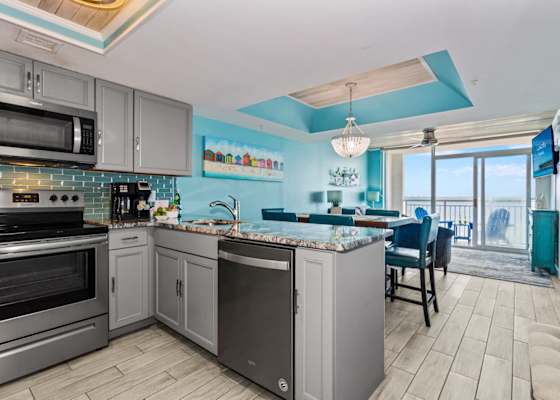 Cook, dine, and relax in this stunning open-concept space featuring a modern kitchen with granite countertops, stainless steel appliances, and vibrant coastal accents. The dining area flows seamlessly to the living room, all with gorgeous ocean views