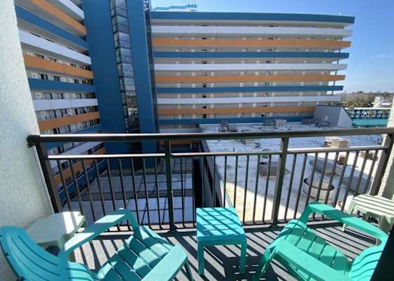 Private balcony featuring colorful Adirondack chairs and a small table overlooking the resort complex