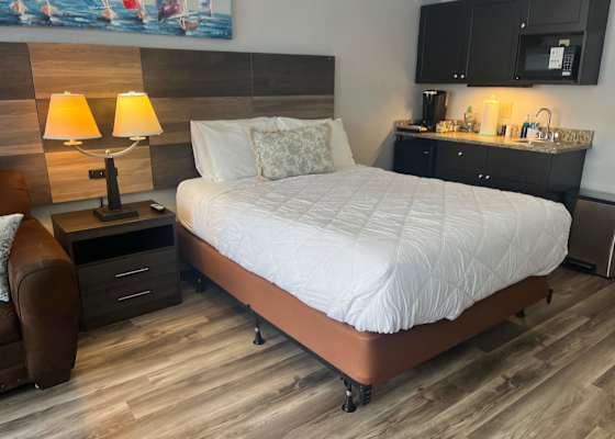 Comfortable secondary sleeping area featuring a plush bed alongside a convenient kitchenette station