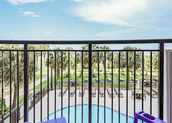 Sip your morning coffee with this view—lush palms, poolside vibes, and the beach path just steps away. Your private balcony is the front row seat to paradise. 