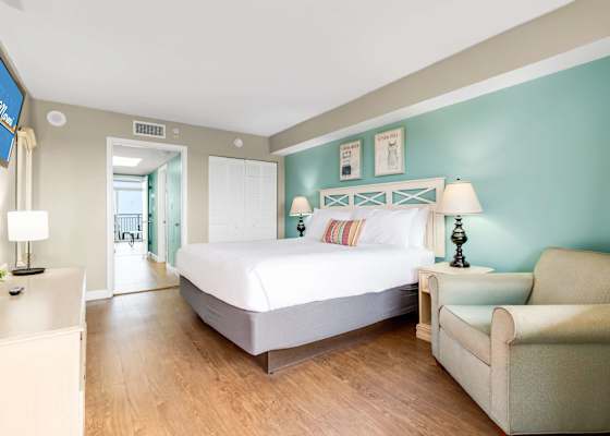 Relax in this bright and spacious bedroom featuring a plush king-sized bed, stylish coastal decor, and ample natural light. Perfect for unwinding after a day of beach adventures!