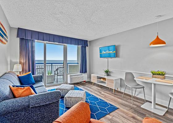 Relax and unwind in the spacious living room with comfortable seating, a large flat-screen TV, and stunning ocean views. 
