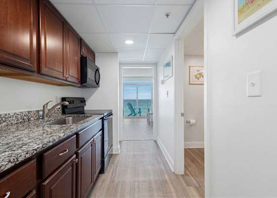 This fully-equipped kitchen features granite countertops, modern appliances, and everything you need to whip up meals, all while enjoying a glimpse of the ocean from the comfort of your vacation retreat.