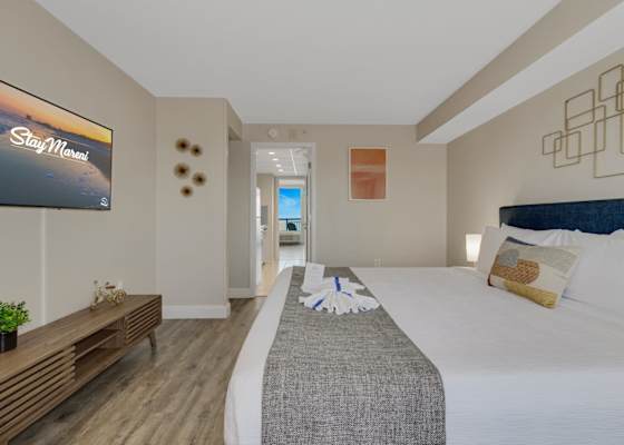 Relax in this serene coastal bedroom featuring plush beds, soft linens, and cheerful pops of color—perfect for unwinding after a day at the beach or waking up to gentle morning light.