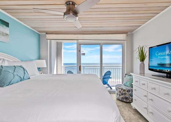 Retreat to this serene bedroom featuring a plush king bed, stylish decor, and a flat-screen TV for entertainment. Wake up to natural light and glimpses of the ocean, creating a perfect blend of comfort and coastal charm.