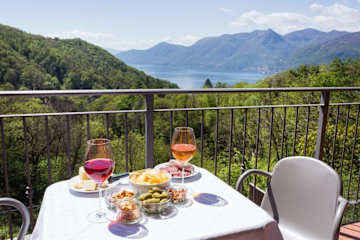 Metal table and chairs on a balcony with lake view