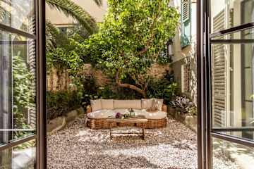 Wicker outdoor sofa in a small courtyard