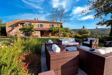 Italian farmhouse behind a swimming pool with loungers