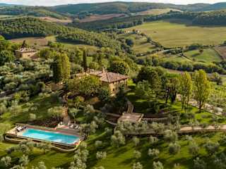 Villa and pool surrounded by fields and woods
