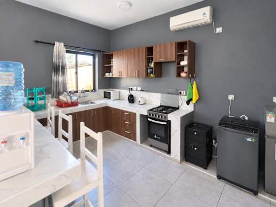 The kitchen has a cooker, microwave, refrigerator and counter space, with air conditioning above.