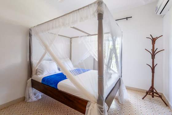 A net-draped bed and coat stand in the apartment’s second sleeping space.