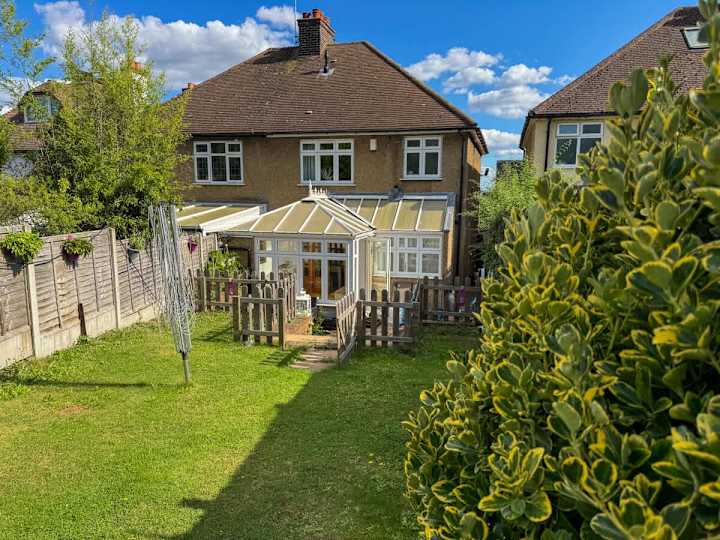Beautiful south facing garden with seating area and grass lawn.