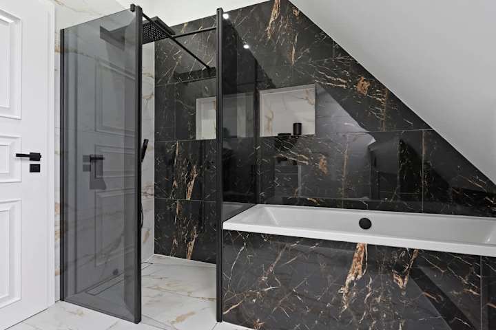 A modern bathroom with a bathtub and separate waterfall shower