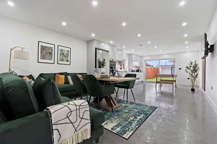 Comfy sofa in a well sized open plan kitchen living room space with dining table and pool table