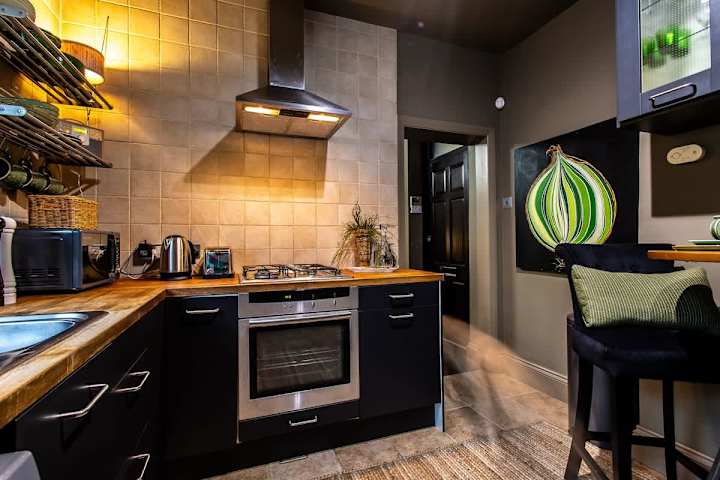 Fully equipped kitchen with a microwave, stove, kettle, and oven.