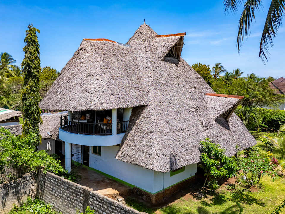 Villa Boba beneath its traditional makuti roof, surrounded by tropical greenery.