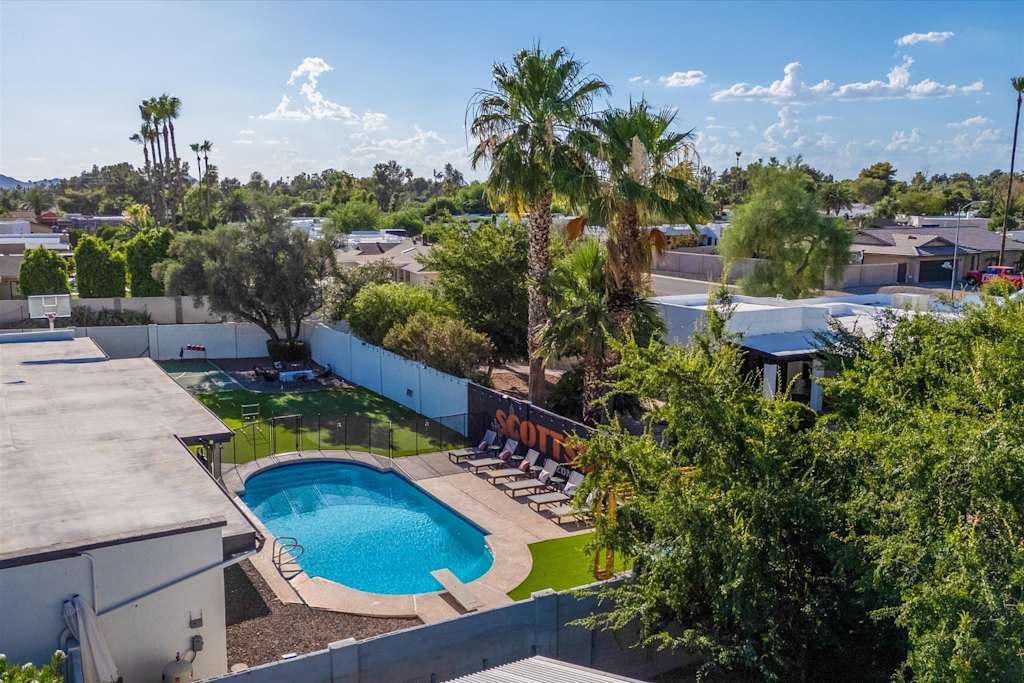 The Sunkiss — high-angle view of a backyard swimming pool, lounge chairs, and surrounding neighborhood