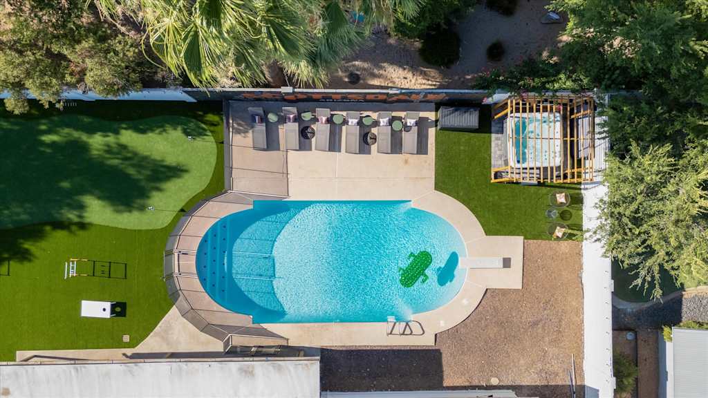 The Sunkiss — overhead view of a swimming pool, lounge patio, hot tub pergola, and turf lawn