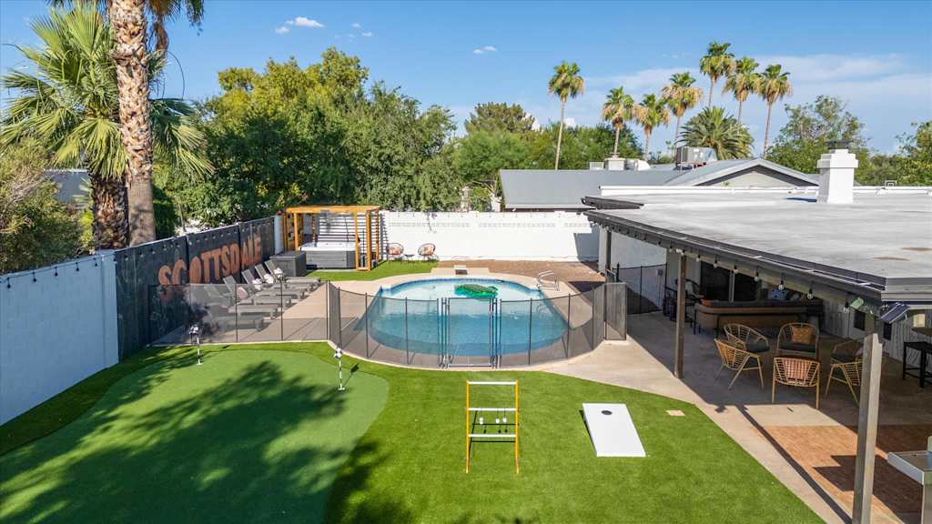 The Sunkiss — overhead view of a backyard with artificial turf putting green, swimming pool, hot tub, and patio