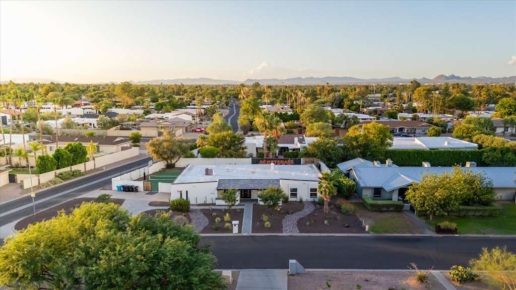 The Sunkiss — aerial view of a single-story vacation home along a suburban street with mountains beyond