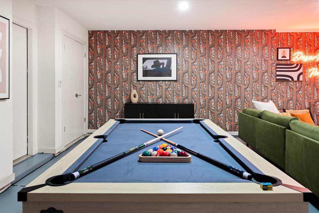 The Sunkiss — pool table with racked billiard balls and crossed cue sticks in a game room with cactus wallpaper