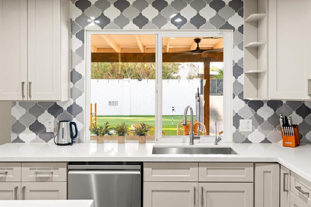 The Sunkiss — kitchen sink with gooseneck faucet under window with views of the backyard and patio area