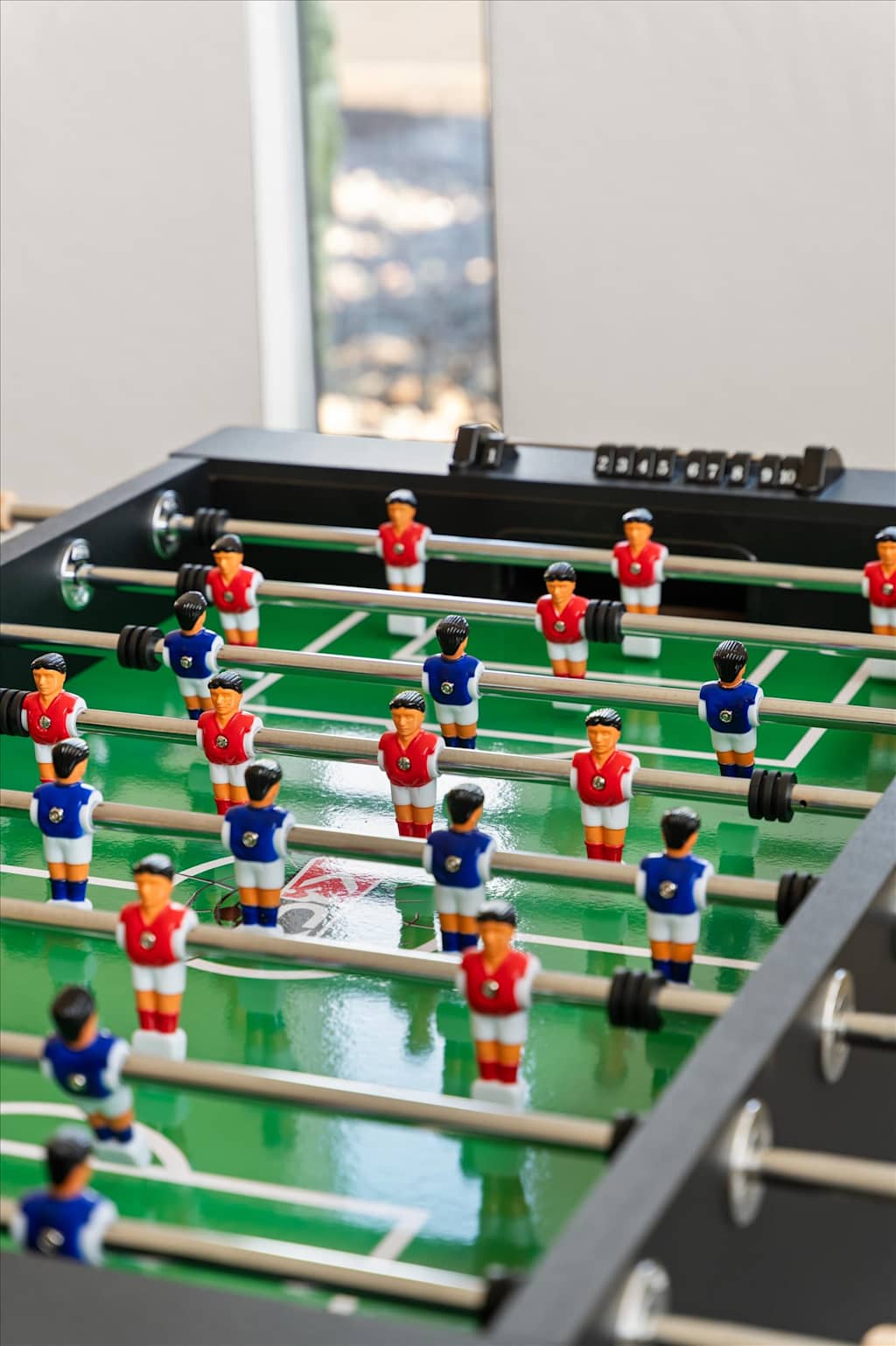 The Sunkiss — close-up view of a foosball table with red and blue miniature players