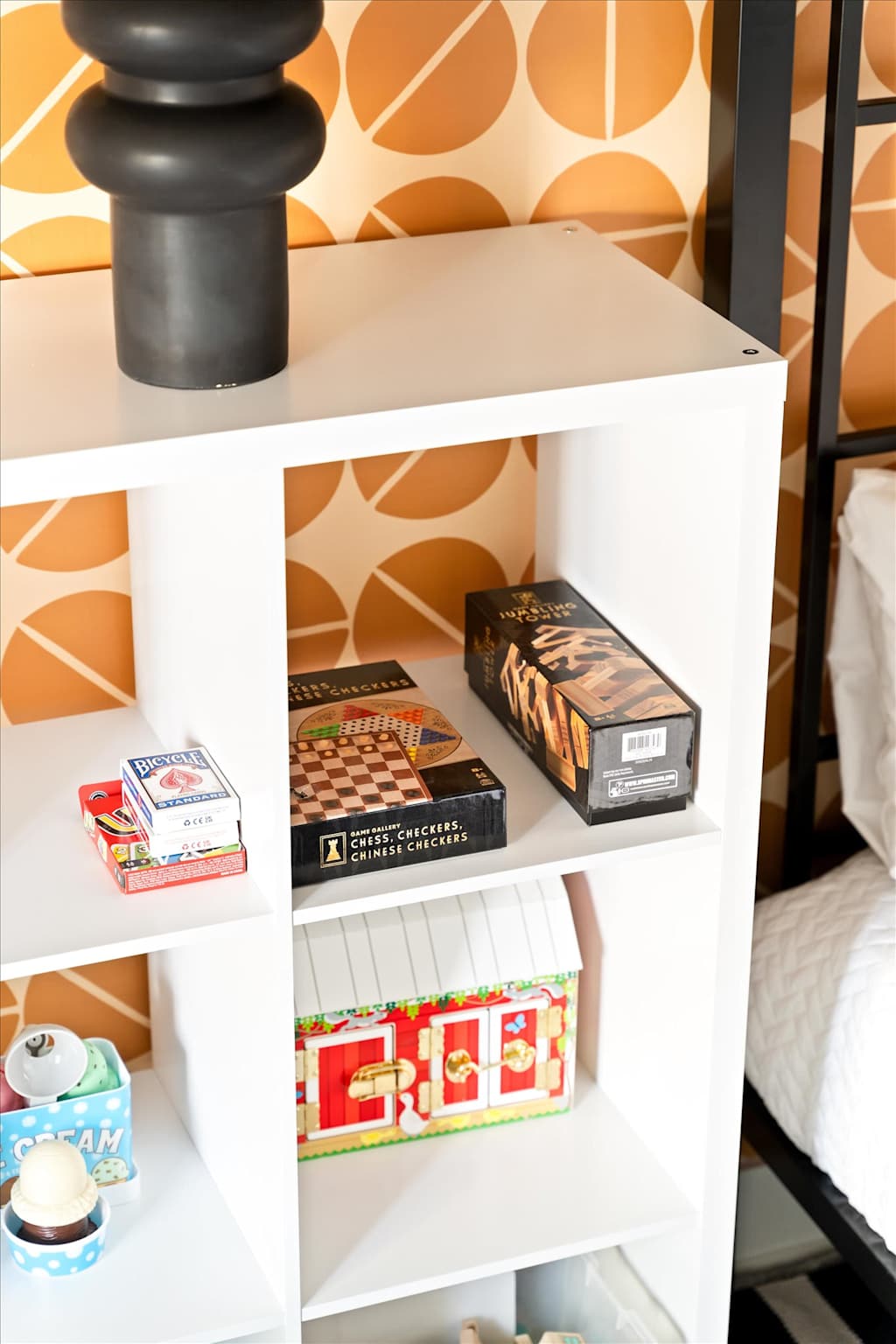 The Sunkiss — white cube shelving unit holding assorted board games, playing cards, and toys