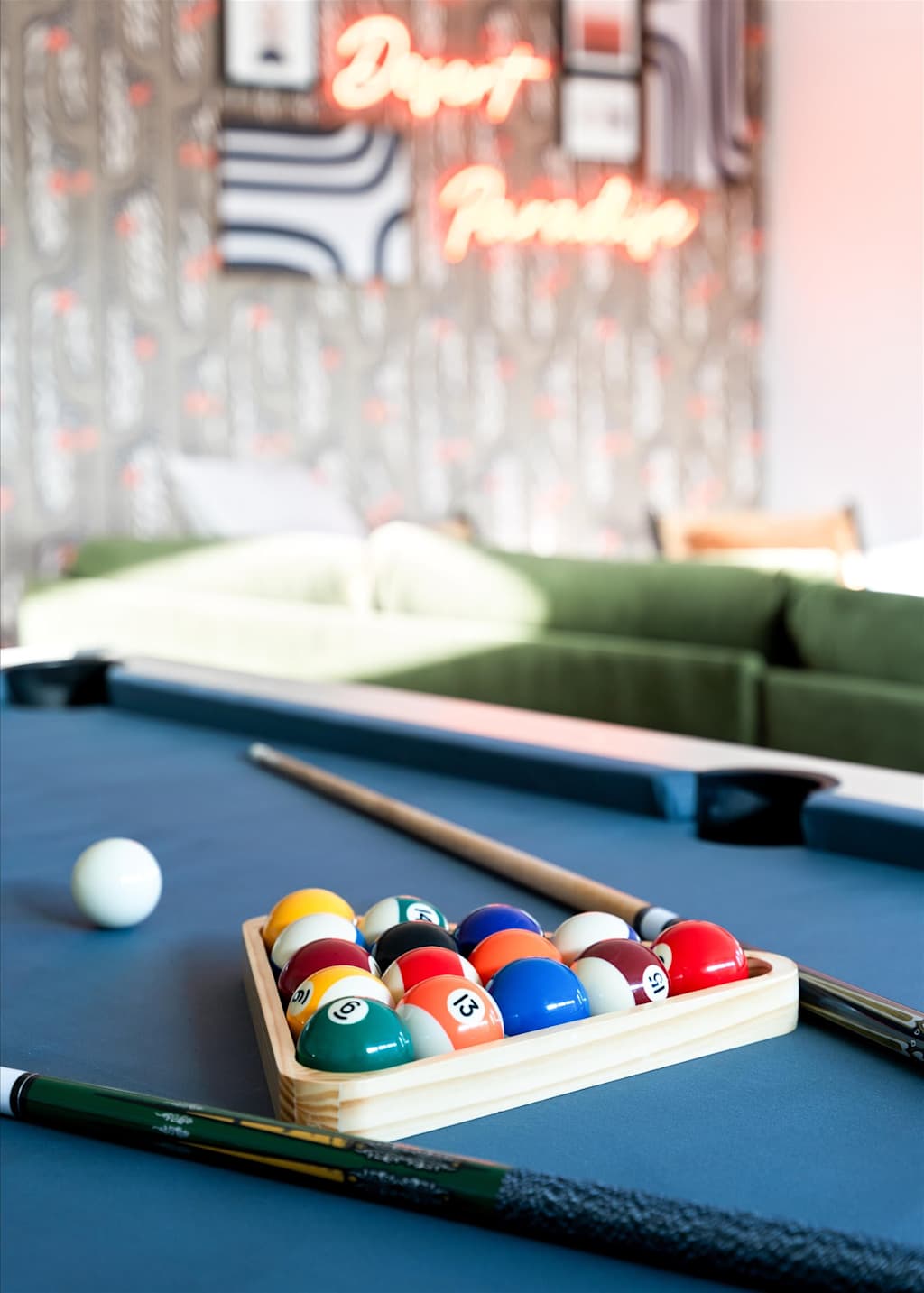 The Sunkiss — racked colorful billiard balls and cue sticks on a blue pool table