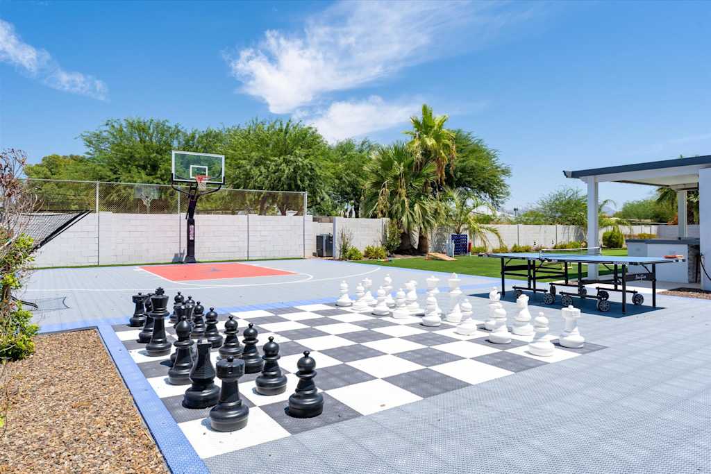 The Scottsdale Social — backyard game area featuring a giant chessboard, ping pong table, and basketball court on sport tiles