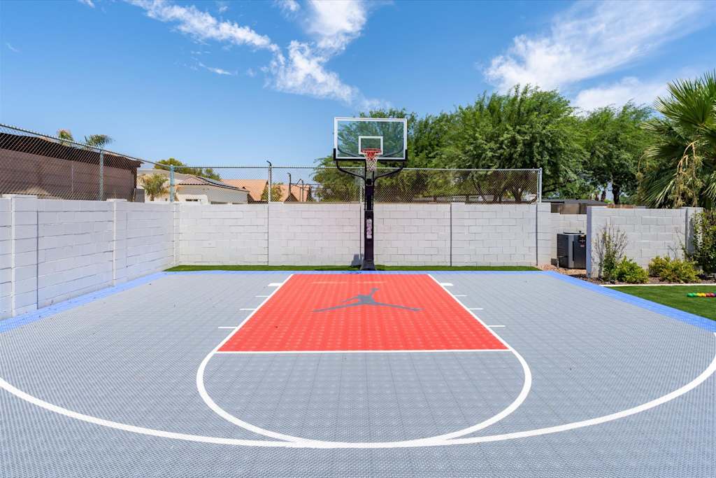 The Scottsdale Social — outdoor half basketball court with blue and red modular tiles, a hoop, and a perimeter wall