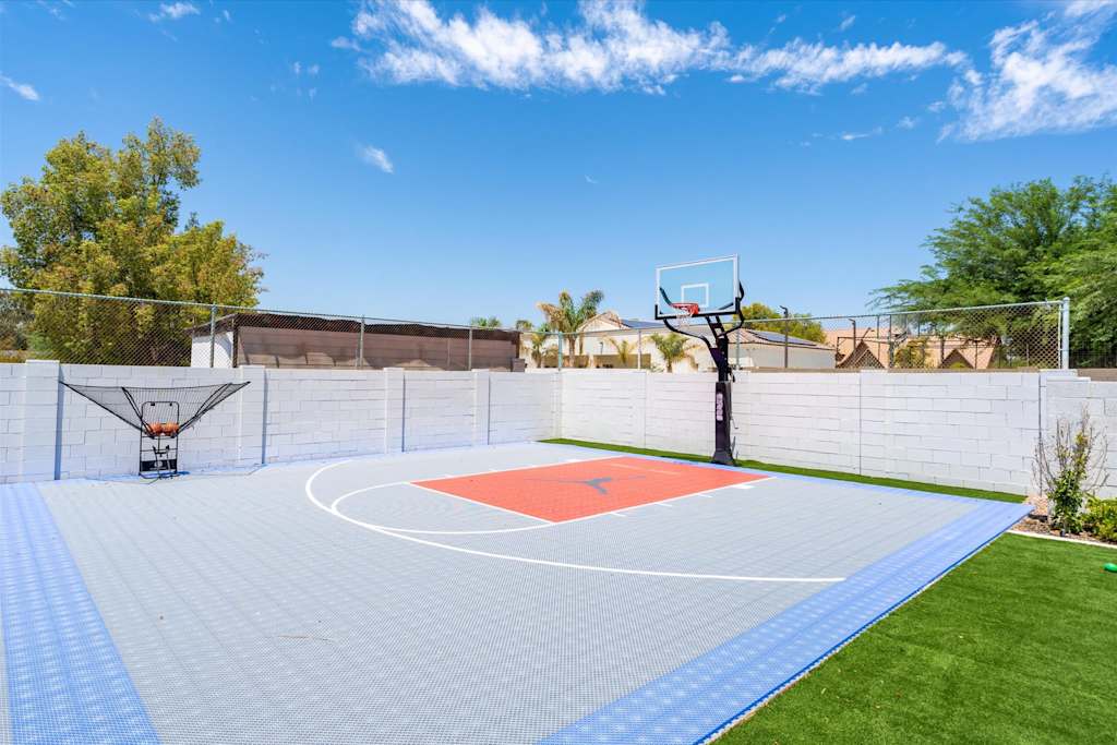 The Scottsdale Social — full view of a backyard basketball court with modular tiles, a hoop, and a ball return net