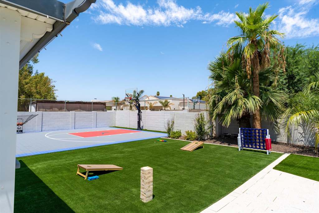 The Scottsdale Social — backyard with basketball half-court, artificial turf lawn, cornhole game, and giant tumbling blocks game