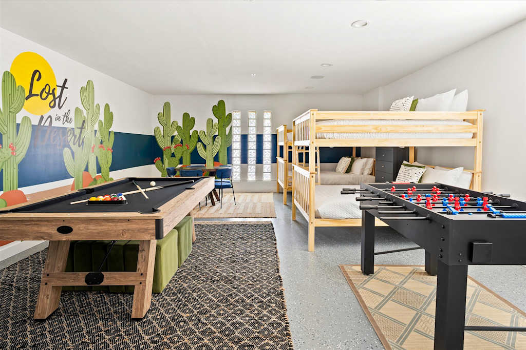 The Scottsdale Social — indoor game room with pool table and foosball table alongside wooden bunk beds and cactus mural