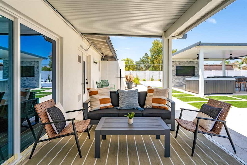 The Scottsdale Social — covered patio lounge with sofa, armchairs, and coffee table on a striped outdoor rug