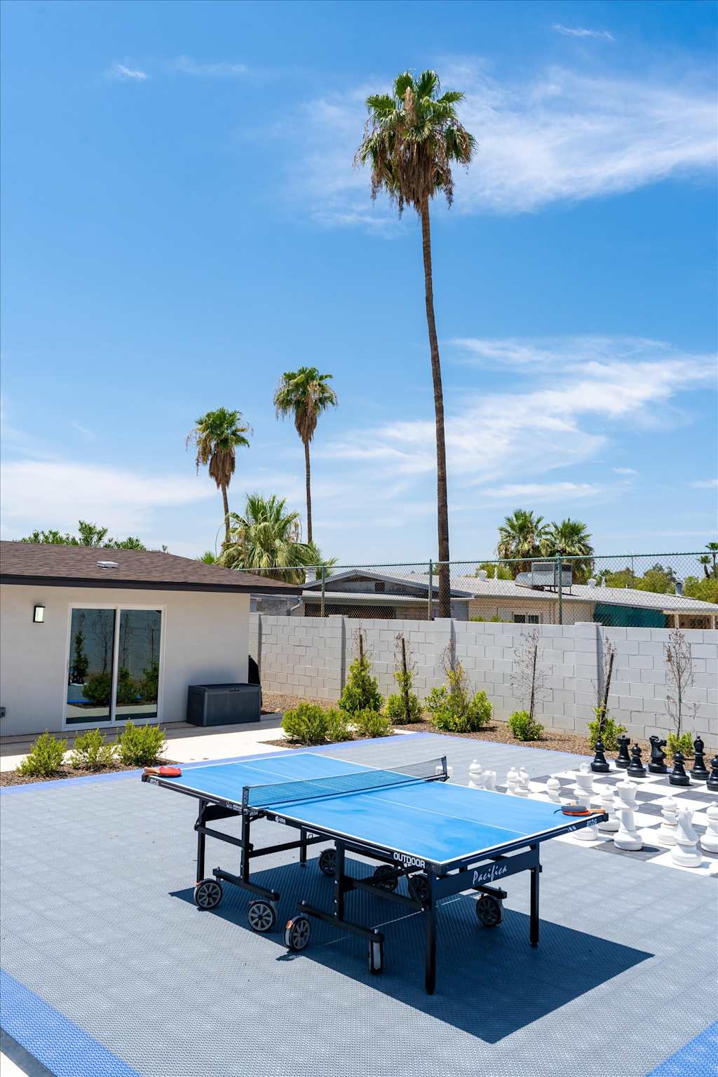 The Scottsdale Social — outdoor game court with a ping-pong table, giant chessboard, and palm trees in the background